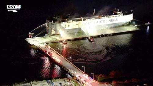 In this image made from aerial video taken Thursday night, firefighters spray a cargo ship with water in Jacksonville, Florida. Authorities say nine firefighters have been hospitalized after the ship exploded.