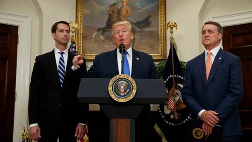 President Donald Trump, flanked by Sen. Tom Cotton, R- Ark., left, and Sen. David Perdue, R-Ga., speaks in the Roosevelt Room of the White House in Washington, Wednesday, Aug. 2, 2017. (AP Photo/Evan Vucci)