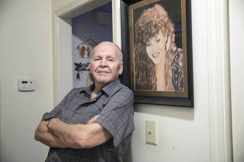 Charles Dillard stands by a gifted painting of himself, performing as Mr. Charlie Brown, that hangs at his residence in Austell. Dillard says that his Aunt Mary lends some of the inspiration for his Mr. Charlie Brown persona.