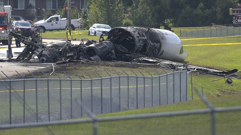 The burned remains of a plane that was carrying NASCAR television analyst and former driver Dale Earnhardt Jr. lie near a runway Thursday, Aug. 15, 2019, in Elizabethton, Tenn. (Earl Neikirk/Bristol Herald Courier via AP)
