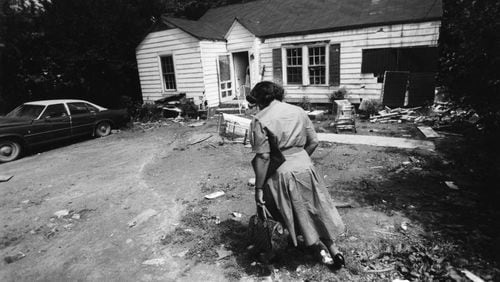 Vale Henson, a DeKalb County social worker, visits a home where children live with flies, garbage and gaping holes in the ceiling. (John Spink / AJC Photo Archive at GSU Library AJCP164-042b)