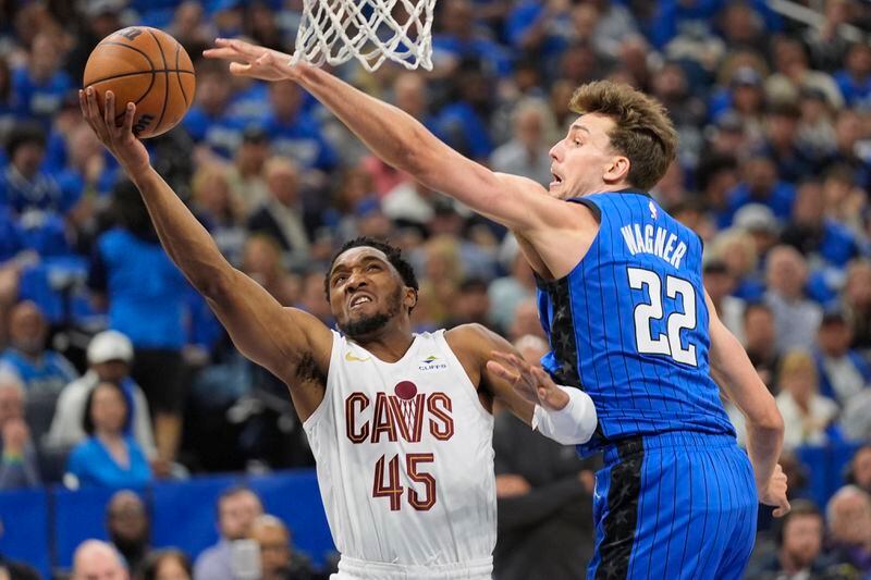Cleveland Cavaliers guard Donovan Mitchell (45) takes a shot around Orlando Magic forward Franz Wagner (22) during the first half of Game 6 of an NBA basketball first-round playoff series, Friday, May 3, 2024, in Orlando, Fla. (AP Photo/John Raoux)