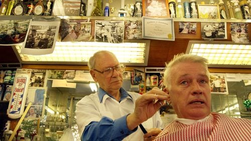 050916 ATLANTA,GA.: At 82, he has been a fixture at his little barber shop, ' The Trim Shop,' near Sixth & Peachtree for more than four decades. But now Eli Sotto (CQ),(left) a survivor of the holocaust has to move to make way for, well, progress. In his shop doing a trim on customer Bob Vance (CQ). (JOEY IVANSCO/ AJC staff)