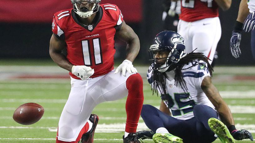 Falcons wide receiver Julio Jones makes a first down catch against Seahawks cornerback Richard Sherman during the third quarter in a NFL football NFC divisional playoff game on Saturday. Curtis Compton/ccompton@ajc.com