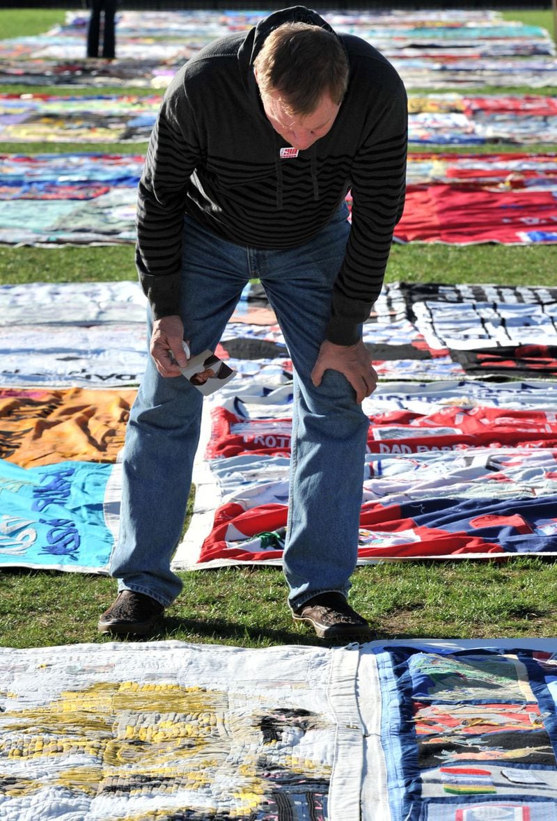 Floyd Taylor, of Atlanta, holds a picture of his lover Larry Moore, who was a graduate student at Emory and died from AIDS in July 2001, as he stopped to view the AIDS Memorial Quilt at Emory University. CREDIT: Hyosub Shin, hshin@ajc.com