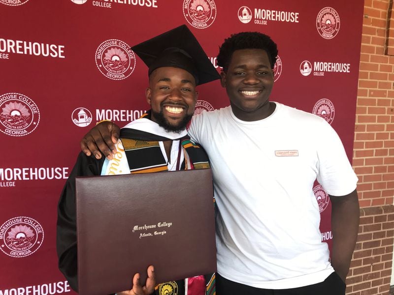 Elijah Dormeus (left) and his brother Jeremiah celebrate after learning that Elijah’s student debt will be paid by a surprise gift from Morehouse College's commencement speaker on Sunday, May 19, 2019. (Photo: Bo Emerson/AJC)
