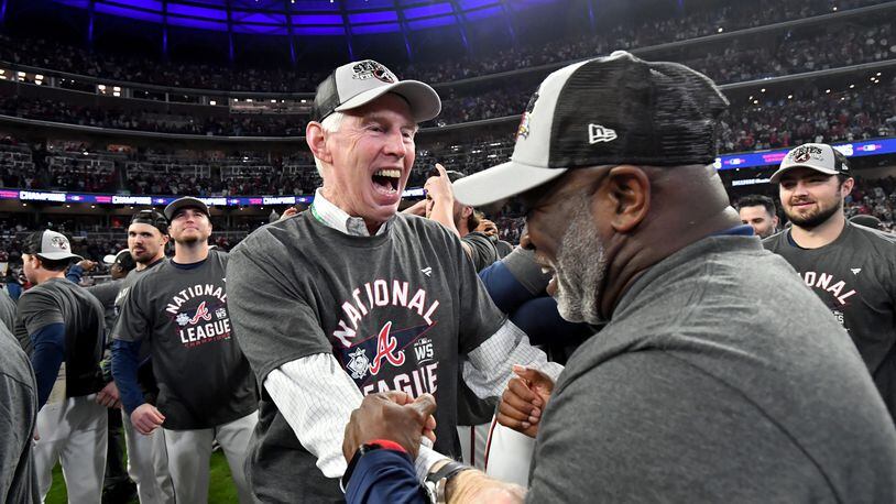Braves chairman Terry McGuirk, facing, celebrates with first base coach Eric Young Sr. on Oct. 23, 2021, after the team eliminated the Los Angeles Dodgers in the National League Championship Series to advance to the World Series.  Hyosub Shin / Hyosub.Shin@ajc.com