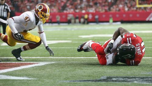Atlanta Falcons wide receiver Julio Jones (11) scores a touchdown after recovering a fumble by Atlanta Falcons running back Devonta Freeman as Washington Redskins defensive back Will Blackmon (41) defends during the second half of an NFL football game, Sunday, Oct. 11, 2015, in Atlanta. (AP Photo/Brynn Anderson)