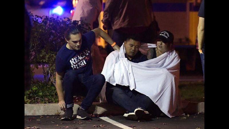Survivors of a mass shooting in Thousand Oaks, California, are comforted outside of the Borderline Bar and Grill.