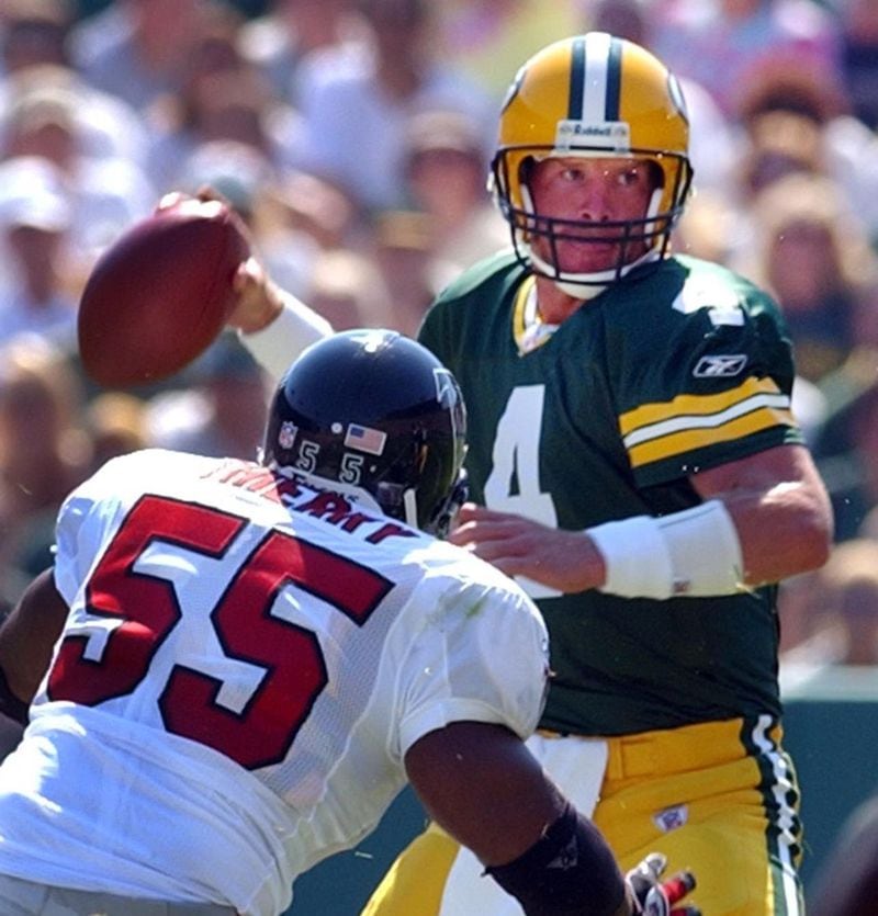 FILE PHOTO -- 020908 GREEN BAY:--RUNNING AWAY FROM THE DEFENSE--Packers quarterback Brett Favre looks to pass under pressure from Falcons linebacker John Thierry during 1st half action at Lambeau Field on Sunday, Sept. 8, 2002. (CURTIS COMPTON/staff)
