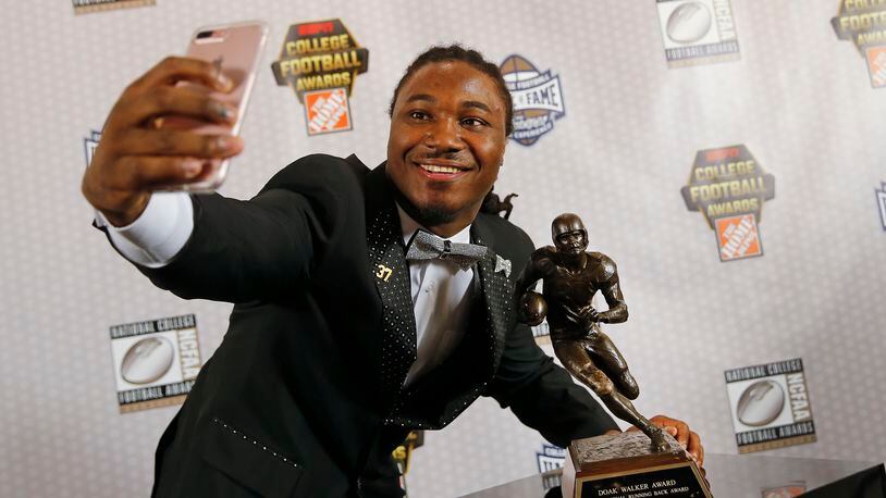 Texas running back D'Onta Foreman takes a selfie with the Doak Walker Award after winning it for being the nation's premier running back Thursday, Dec. 8, 2016, in Atlanta. (AP Photo/John Bazemore)