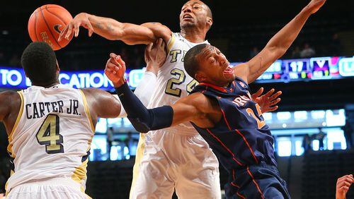 020313 ATLANTA: Georgia Tech forward Kammeon Holsey (center) and Virginia forward Akil Mitchell battle for a rebound during the first half of their NCAA college basketball game on Sunday, Feb. 3, 2013, in Atlanta. CURTIS COMPTON / CCOMPTON@AJC.COM