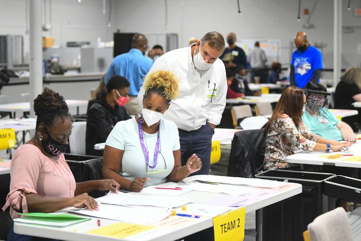 An election official watches oveer the shoulder of workers as votes for President are recounted at the Gwinnett County elections office on Friday, Nov.13, 2020 in Lawrenceville. (JOHN AMIS FOR THE ATLANTA JOURNAL-CONSTITUTION)