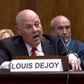 Postmaster General Louis DeJoy speaks before the U.S. Senate during a hearing Tuesday to discuss widespread mail delays.