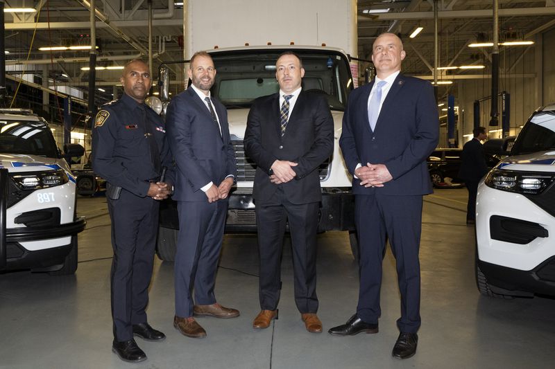 Chief Nishan Duraiappah, left, Detective Sergeant Mike Mavity, and ATF Special Agent in Charge, Eric DeGree, right, pose in front of a recovered truck during a press conference regarding Project 24K a joint investigation into the theft of gold from Pearson International Airport, in Brampton, Ontario, on Wednesday, April 17, 2024. (Arlyn McAdorey/The Canadian Press via AP)