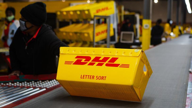 A DHL box is sent down the conveyer belt on Wednesday, December 16, 2020, at DHL Express in Atlanta. Workers at the shipping center worked to fulfill orders during the holiday rush. CHRISTINA MATACOTTA FOR THE ATLANTA JOURNAL-CONSTITUTION.