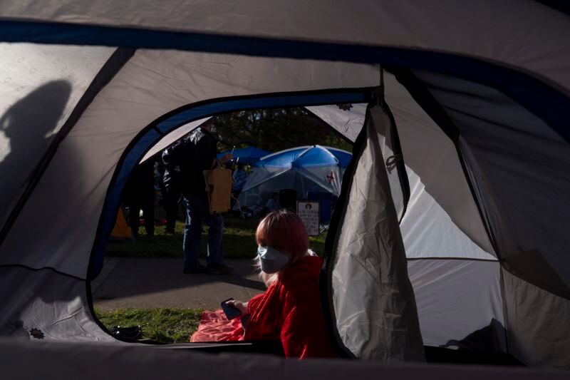 A student at the University of Oregon looks into a tent with other students at an encampment at the university that was set up to protest the Israel-Hamas war on Monday, April 29, 2024, in Eugene, Ore. (AP Photo/Jenny Kane)