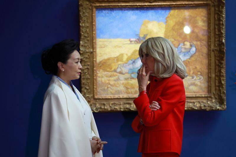 China's President Xi Jinping's wife Peng Liyuan, center, and French President Emmanuel Macron's wife Brigitte Macron, right, visit the Orsay Museum, Monday, May 6, 2024 in Paris. China's President Xi Jinping is in France for a two-day state visit that is expected to focus both on trade disputes and diplomatic efforts to convince Beijing to use its influence to move Russia toward ending the war in Ukraine. (AP Photo/Aurelien Morissard, Pool)