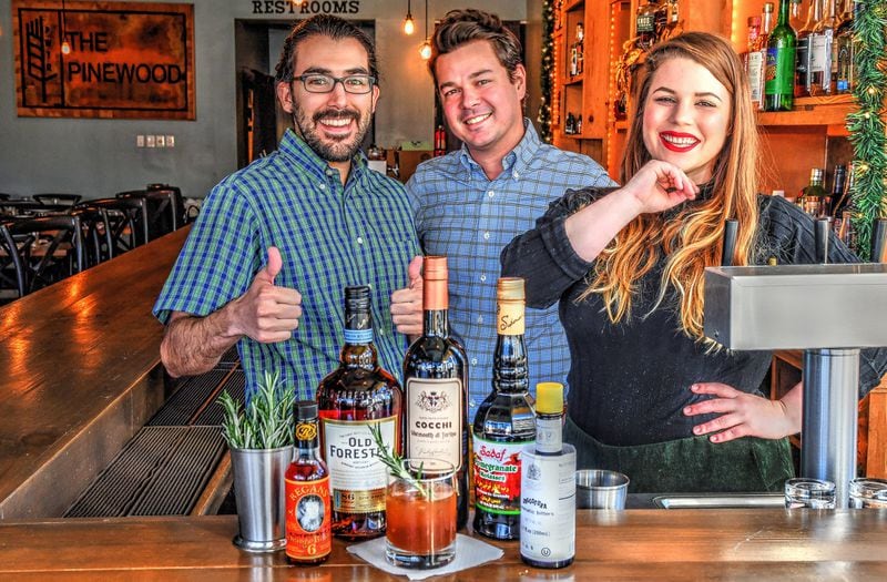 Bartenders Martín Aramayo (from left) and Zachary Williams and bar manager Kasey Emmett stand behind their collaborative drink, Rosemary’s Baby, featured at the Pinewood in downtown Decatur. STYLING BY KASEY EMMETT / CONTRIBUTED BY CHRIS HUNT PHOTOGRAPHY