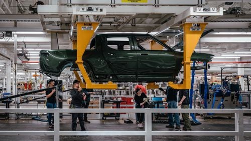 Workers assemble components of a Rivian electric vehicle at the company's manufacturing facility in Normal, Ill., on April 11, 2022. MUST CREDIT: Bloomberg photo by Jamie Kelter Davis