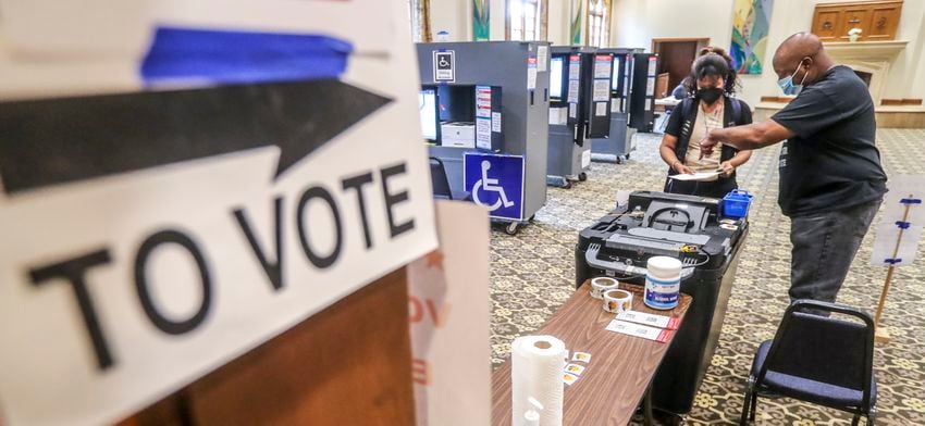 June 21, 2022 Atlanta: With a light morning voter turnout, C. Harper (left) turns in her ballot to poll worker, Michael Bacon (right) at Saint Luke’s Episcopal Church at 435 Peachtree St NE, Atlanta on Tuesday, June 21, 2022. (John Spink / John.Spink@ajc.com)

