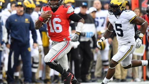 J.T. Barrett of the Ohio State Buckeyes rushes the ball during overtime against the Michigan Wolverines at Ohio Stadium on November 26, 2016 in Columbus, Ohio. (Photo by Jamie Sabau/Getty Images)