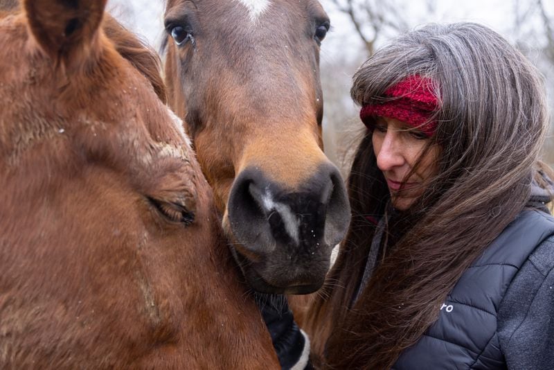 Michelle Graef shares a moment with her horses while posing for a portrait at her farm in East Palestine, Ohio, on Friday, February 17, 2023. (Arvin Temkar / arvin.temkar@ajc.com)