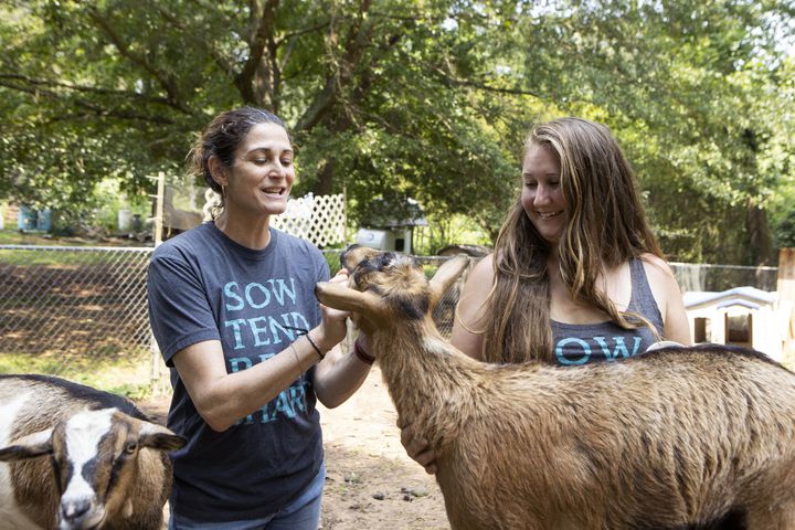Judy Byler (left), founder and CEO of Our Giving Garden, and Hillary Jensen, director of Our Giving Garden, try to rally the farm animals for a photo on Wednesday, June 7, 2023, in Mableton, Georgia. Our Giving Garden is a nonprofit community garden that donates fresh produce to families without access to it. CHRISTINA MATACOTTA FOR THE ATLANTA JOURNAL-CONSTITUTION.
