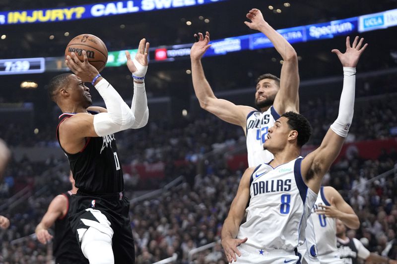Los Angeles Clippers guard Russell Westbrook, left, shoots as Dallas Mavericks forward Maxi Kleber, center, and guard Josh Green defend during the first half in Game 2 of an NBA basketball first-round playoff series Tuesday, April 23, 2024, in Los Angeles. (AP Photo/Mark J. Terrill)