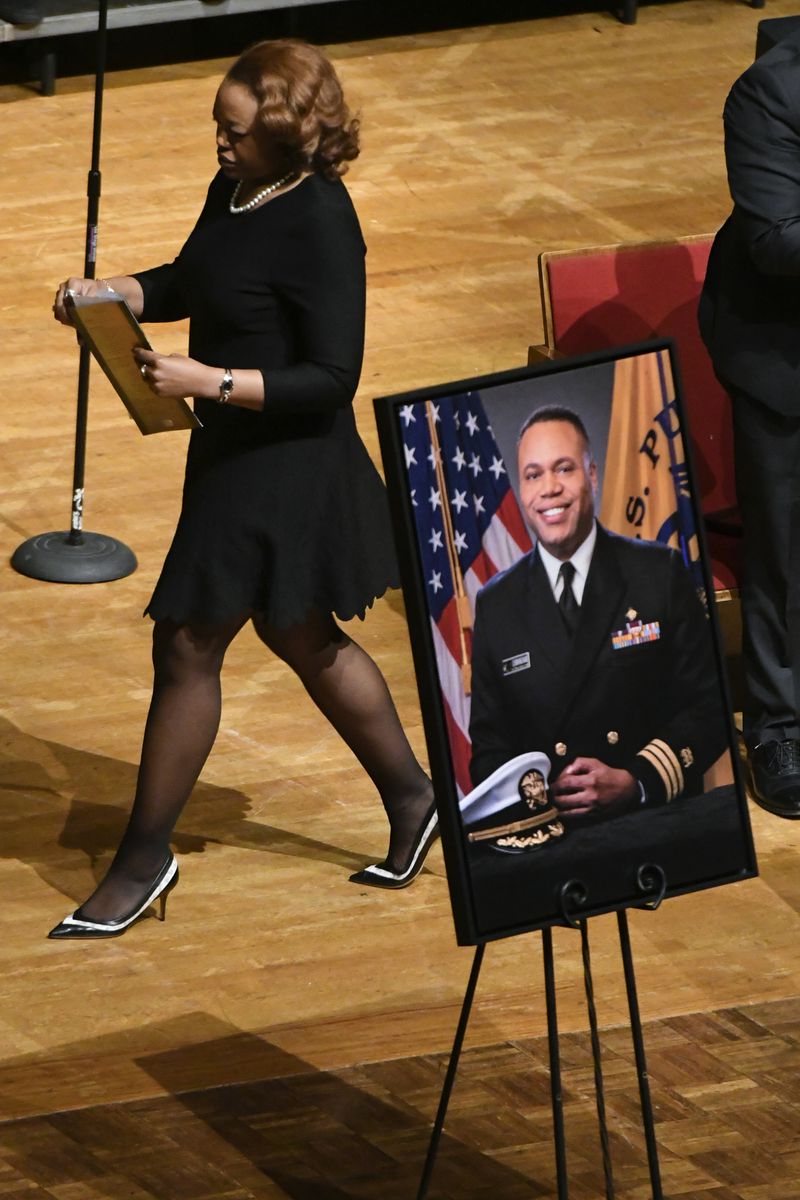 Tiara Cunningham walks past an image of her brother during a memorial service for CDC researcher Timothy Cunningham, who was pulled from the Chattahoochee River after being missing for seven weeks, held Saturday at Morehouse April 21, 2018. (John Amis Contributed)