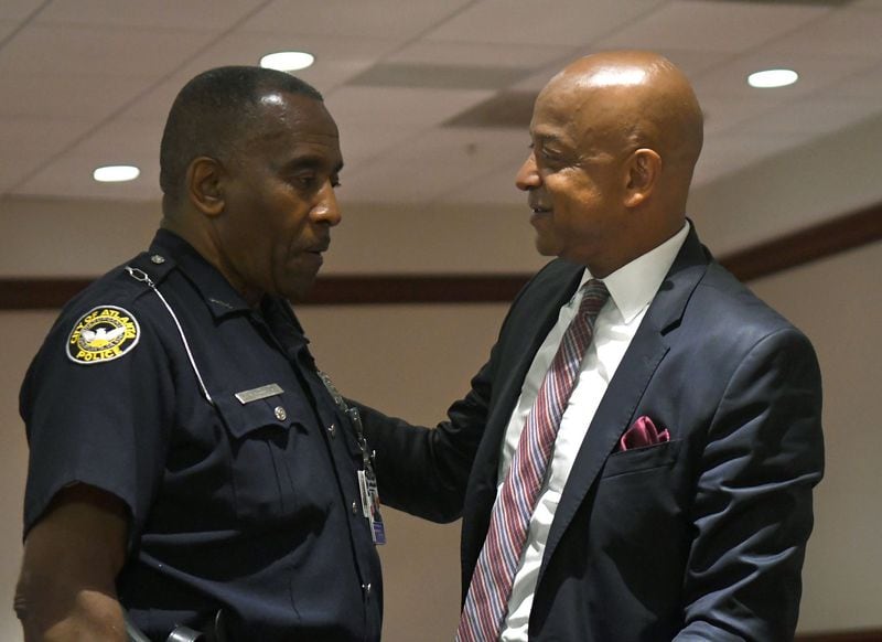 Officer C.J. Maddox Jr. (left) speaks with DeKalb County Sheriff Jeff Mann (right) before Mann pleaded guilty to charges of obstruction and prohibited conduct in Atlanta Municipal Court on July 27, 2017. (Photo by Rebecca Breyer/AJC)