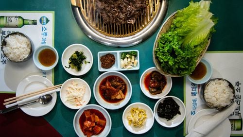 Here’s a typical meal at Hae Woon Dae on Buford Highway. On the grill is bulgogi (top), the classic marinated beef shortrib common in Korean cuisine. Below it is a selection of typical banchan, all made in-house at Hae Woon Dae. CONTRIBUTED BY HENRI HOLLIS