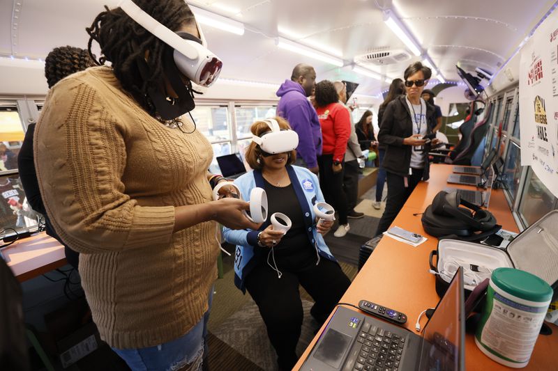 Morehouse College chemistry professor Muhsinah Morris (left) gives interim DeKalb County School District Superintendent Vasanne Tinsley a virtual reality tour of the college inside the district's new Student Success Mobile Center at Lithonia High School on Wednesday, March 29, 2023. (Miguel Martinez / miguel.martinezjimenez@ajc.com)