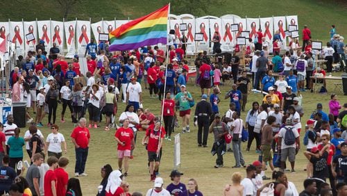 Marion Lenz walks through the crowd with a rainbow flag during the 27th Annual AIDS Walk Atlanta & 5K Run at Piedmont Park on Oct. 22, 2017.