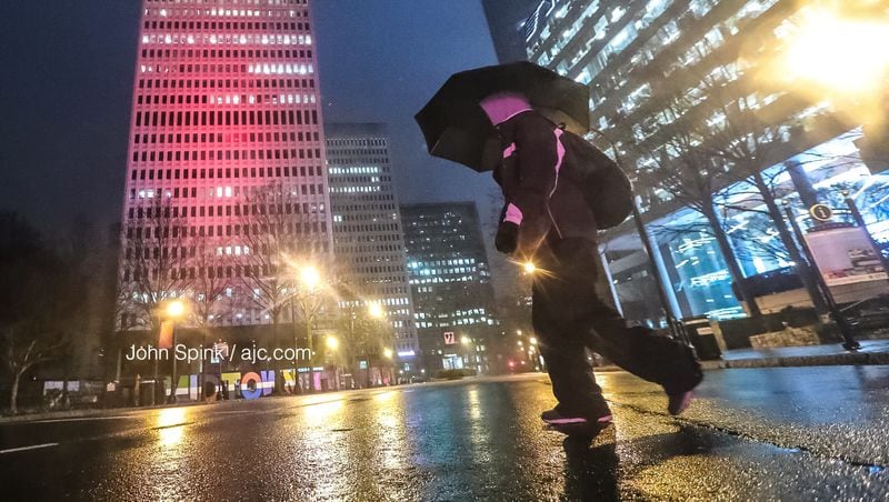 M.J. Parker crosses Peachtree Street in Midtown during another day of rain. Light drizzle Wednesday morning could turn into heavy downpours in the afternoon, according to Channel 2 Action News. JOHN SPINK / JSPINK@AJC.COM
