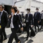 Japan's health ministry officials walk towards the Osaka plant of Kobayashi Pharmaceutical Co. to conduct an on-site inspection in Osaka, western Japan, Saturday, March 30, 2024. Japanese government health officials raided a factory Saturday producing health supplements that they say have killed multiple people and hospitalized more than 100 others.