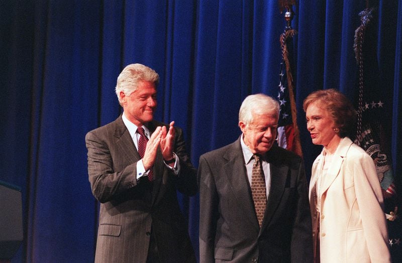 President Bill Clinton applauds Carter and his wife Rosalynn before presenting the Presidential Medal of Freedom at the Carter Center on Aug. 9, 1999. (Ben Gray / AJC file)