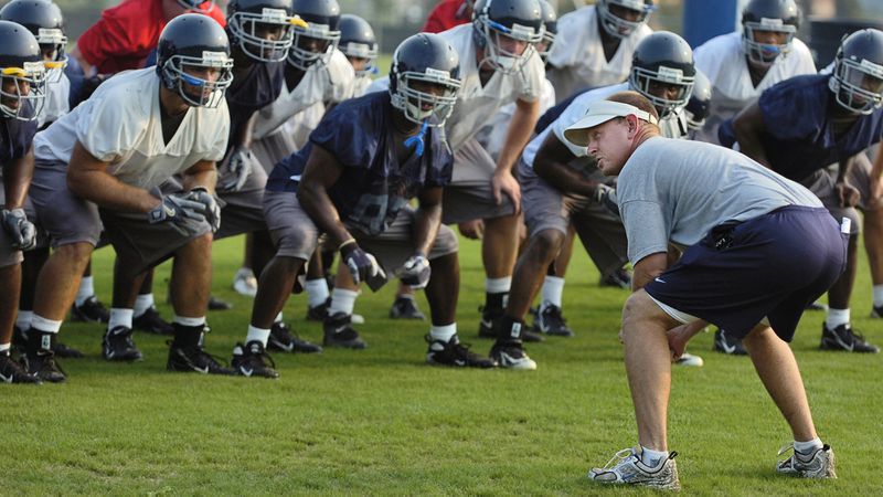 Chris Hatcher, right, leads his Georgia Southern team in the "Beautiful Eagle Creek Salute" during a preseason practice in 2007, shortly after  he  had been hired as head coach. (AP Photo/the Statesboro Herald, Scott Bryant)
