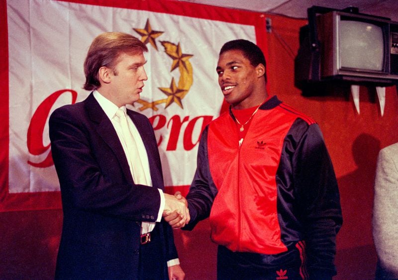 In this March 8, 1984, file photo, Donald Trump shakes hands with Herschel Walker in New York after agreement on a 4-year contract with the New Jersey Generals USFL football team. The New Jersey Generals have been largely forgotten, but Trumps ownership of the team was formative in his evolution as a public figure and peerless self-publicist. With money and swagger, he led a shaky and relatively low-budget spring football league, the USFL, into a showdown with the NFL. (AP Photo/Dave Pickoff, File)