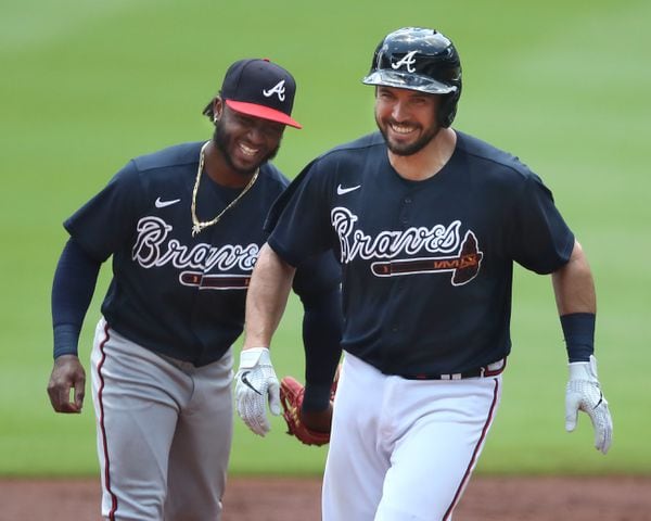 Braves catcher Travis D’Arnaud is all smiles rounding second past Ozzie Albies after his 2-run homer.   Curtis Compton ccompton@ajc.com