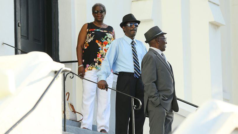 Church members stand on the steps and take in the crowd waiting to get in for Sunday service at the Mother Emanuel AME Church on June 21, 2015, in Charleston, S.C., several days after a gunman killed nine black people there. CURTIS COMPTON/ CCOMPTON@AJC.COM