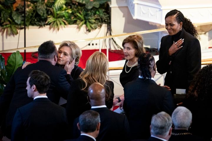 From left: Garth Brooks kisses Hillary Clinton, followed by Laura Bush and Michelle Obama, after the memorial for former first lady Rosalynn Carter at Glenn Memorial Church in Atlanta, Nov. 28, 2023. (Erin Schaff/The New York Times)