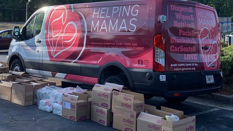 Packages of diapers in front of the Helping Mamas mobile van. Helping Mamas uses the van to transport baby supplies to the metro Atlanta community by hosting pickup events at churches, schools and other public locations. (Jamie Lackey)