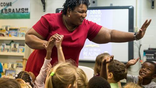 Stacey Abrams touches the hands of multiple preschool-aged children after reading them a children's book during a "Get Georgia Reading" literacy campaign stop at Seminole County Elementary School in Donalsonville, Ga. (File photo)