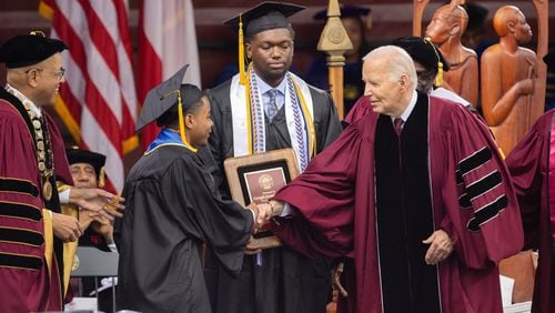 President Joe Biden shakes hands with salutatorian Dwayne Allen Terrell II (left) at the commencement ceremony at Morehouse College in Atlanta on Sunday, May 19, 2024. (Arvin Temkar / AJC)