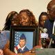 Chantemekki Fortson, mother of Roger Fortson, a U.S. Air Force senior airman, holds a photo of her son during a news conference regarding his death, with Attorney Ben Crump, right, Thursday, May 9, 2024, in Ft. Walton Beach, Fla. Fortson was shot and killed by police in his apartment on May 3, 2024. (AP Photo/Gerald Herbert)