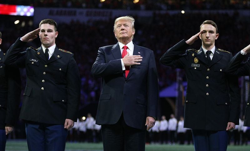 President Donald Trump participates in the national anthem at the College Football Playoff National Championship at Atlanta’s Merceds-Benz Stadium on Monday, January 8, 2018.    