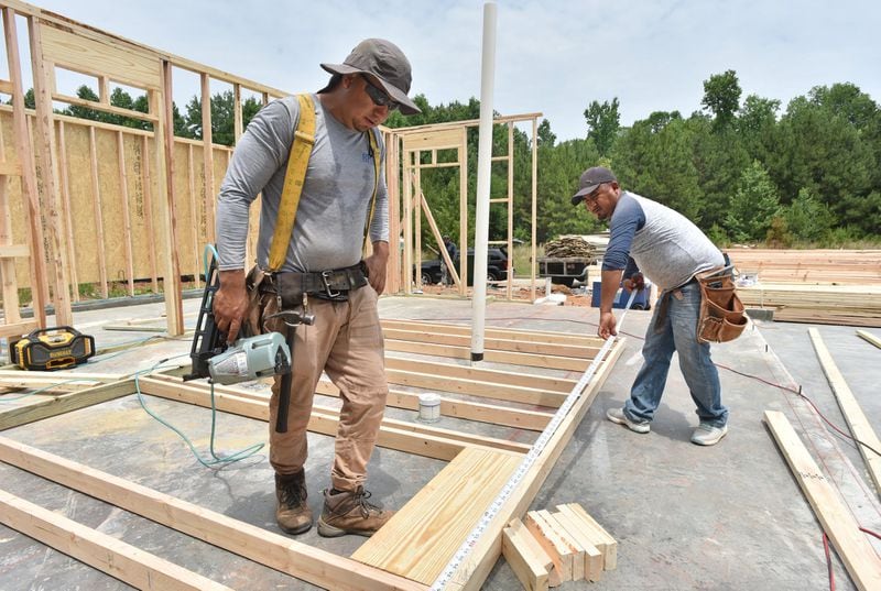 Gonzalo Gonzalez (left) and his brother Pablo Gonzalez (both construction workers) prepare framing the structure of a new construction townhome community at Old Ivy Place in Jonesboro on Tuesday, June 4, 2019. Housing market data company Metrostudy says Clayton County has only 1.9 months inventory of available pre-owned housing and seven months of new homes. That’s lower than the metro Atlanta average of 2.6 months inventory of pre-owned houses for resale and eight months of new homes. HYOSUB SHIN / HSHIN@AJC.COM