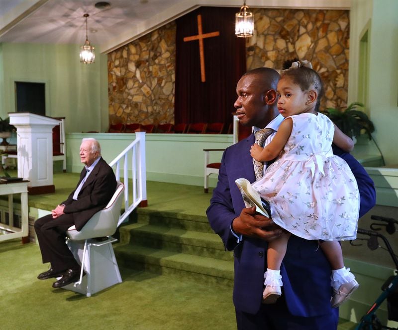 June 9, 2019 Plains: Reverend Tony Lowden holds his daughter Tabitha in the sanctuary of Maranatha Baptist Church greeting visitors with President Jimmy Carter after leading the worship service on Sunday, June 9, 2019, in Plains.  Curtis Compton/ccompton@ajc.com