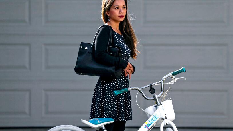 The Buy Nothing program builds community through the gifting economy worldwide. Stacey Doan (pictured) of Claremont, California acquired the dress she is wearing, earrings, purse and youth bicycle through Buy Nothing. There are more than 100 Buy Nothing groups in Georgia that allow neighbors to find or request free items from other neighbors. (Irfan Khan/Los Angeles Times/TNS)